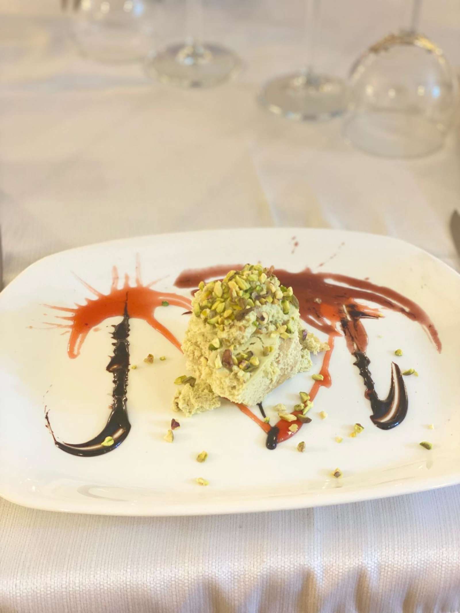 Semifreddo al pistacchio decorato con salsa ai frutti di bosco